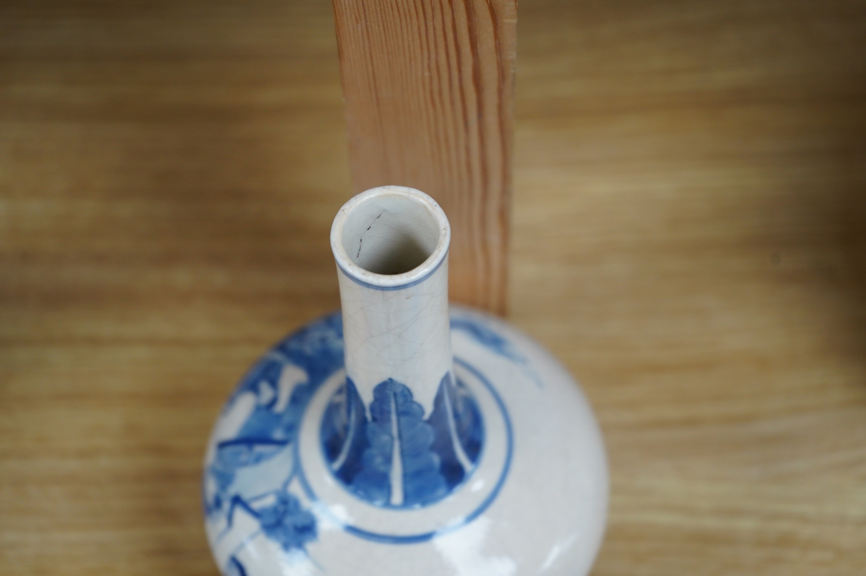 A 19th century Chinese blue and white crackle glaze bottle vase on hardwood stand, 20cm total. Condition - firing cracks to neck interior